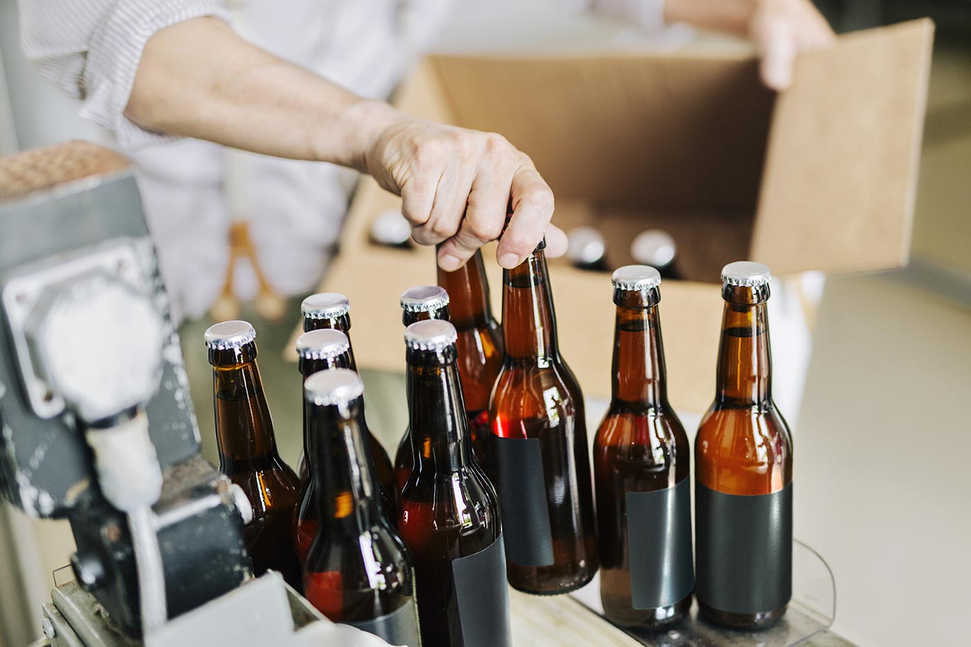 brewery-worker-preparing-beer-bottles-U498MD9